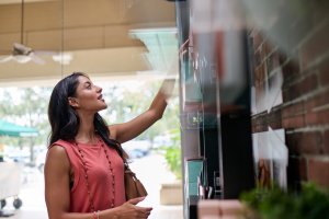 Woman shopping for skincare product at Waxing the City