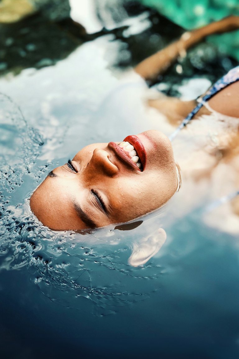 Woman floating in water with her face above the waterline.