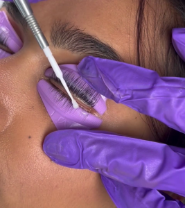 Woman receiving eyelash lifting treatment.

