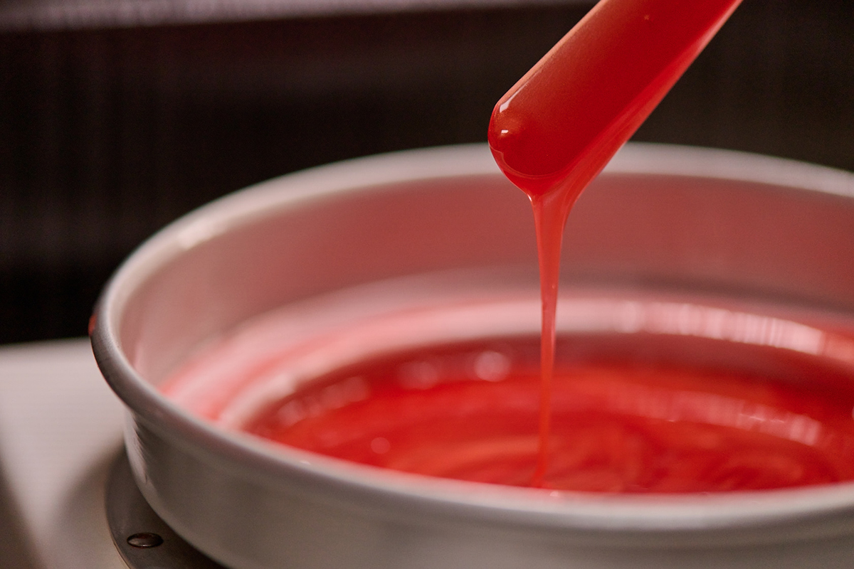 Pot of wax with a wooden application dipped in.